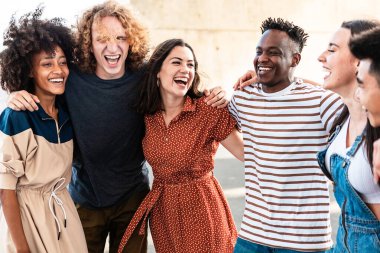 Genç bir grup insan dışarıda birlikte eğleniyor. Dışarıda birbirine sarılırken gülen çok ırklı arkadaşlar. Gençlik toplumu kavramı