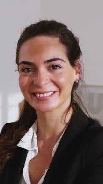 Ofisinde kollarını kavuşturmuş, güven ve profesyonellik saçan neşeli bir iş kadınının dikey HD videosu. Güçlendirme ve yeni iş konsepti