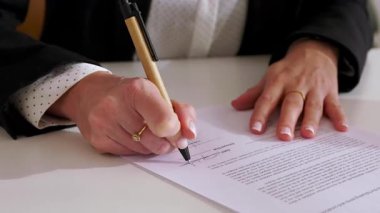 Genç iş kadınlarının ofiste kontrat imzalamalarına yakından bakın. Yeni fırsat, işe alım ya da anlaşma.
