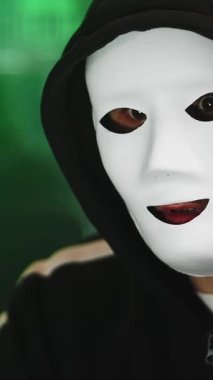 Maskeli bilgisayar korsanının karanlık odada siber saldırı hazırlarken çekilmiş dikey HD videosu. Siber uzay casus konsepti