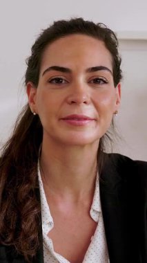 Dikey video. İş yerinden laptopla yapılan görüntülü konuşmayı dinleyen mutlu, genç bir bayanı kapatın. Genç girişimci bayan partnerle çevrimiçi görüşme yoluyla konuşuyor