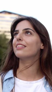 Düşünceli, genç ve güzel bir kadının açık havada düşünürken çekilmiş dikey HD videosu. Gülümseyen genç bayan turist Barselona 'yı geziyor..