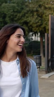 Şehirde yürürken takılan üç mutlu çok ırklı genç arkadaşın dikey HD videosu. Çok ırklı genç lise öğrencileri birlikte eğleniyor ve gülüyorlar.