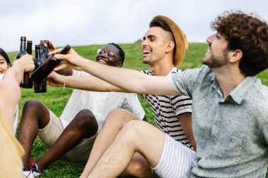 Bir grup genç arkadaş yaz tatili boyunca bira içerek eğleniyorlar. Birlikte şehir parkında çimlerde oturuyorlar.