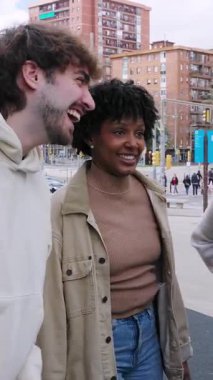 Dışarıda eğlenen genç insanların dikey HD videosu. Dört farklı milenyum arkadaşı açık havada eğleniyor. Gençlik toplumu ve arkadaşlık kavramı.