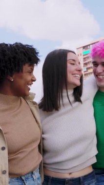 Farklı milenyum insanlarından oluşan genç bir grubun dikey HD videosu. Şehir caddesinde yürürken birbirlerine sarılırken eğleniyorlar. Gençlik toplumu ve arkadaşlık kavramı