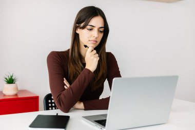 Evde dizüstü bilgisayar kullanan genç bir kadın. Eğitim yaşam tarzı veya iş konsepti.