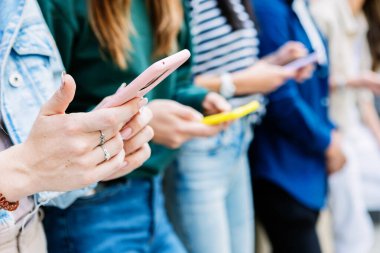 Şehir caddesinde cep telefonu kullanan tanınmayan bir grup genç. Sosyal medya ve teknoloji yaşam tarzı kavramı
