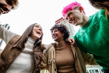 Multiracial young group of student friends laughing together outside. Generation z people bonding, enjoying free time at city street. Youth concept