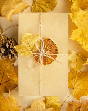 Sonbahar kompozisyonu. Arka planda sonbahar yaprakları olan bir hediye kutusu. Sonbahar, Cadılar Bayramı, Şükran Günü konsepti.