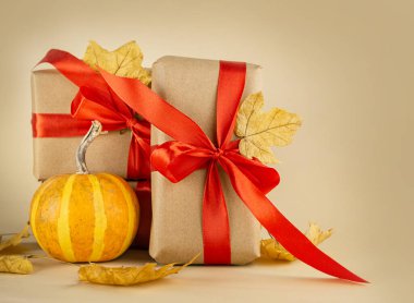 Sonbahar kompozisyonu. Hediye kutuları, arka planda sonbahar yaprakları olan taze balkabakları. Sonbahar, Cadılar Bayramı, Şükran Günü konsepti.