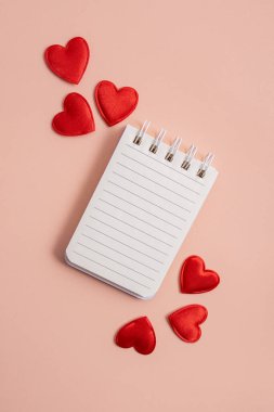 Notebook with hearts on a light background. Valentine concept, mother's day, birthday card. Flat lay, top view. Copy space.