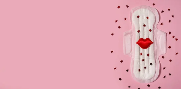 Sanitary napkin in red sequins on a pink background. The concept of female menstruation. The period of the menstrual cycle. Banner. Copy space.