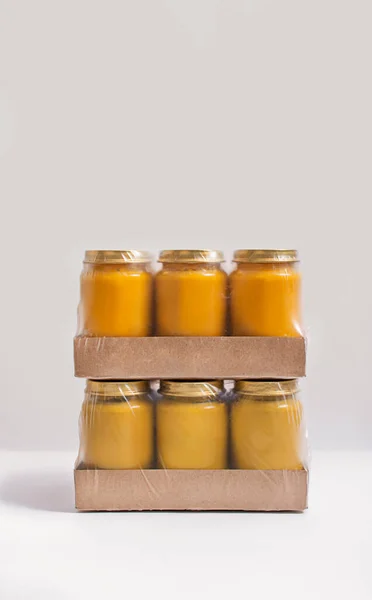 Packaging with cans of baby puree on a white background. Baby food. The first complementary food.