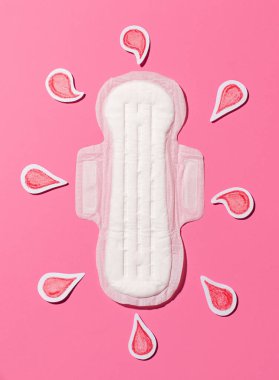 Sanitary napkin with red drops of blood cut out of paper on a pink background. Female menstruation. Menstruation concept.