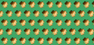 St. Patrick's Day background. Golden shamrock on a green background. Pattern. Copy space.