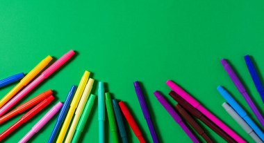 Yeşil arka planda keçeli kalemler. Boşluğu kopyala.