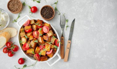 Fırında patates, taze domates ve seramik kapta mikro yeşillikler. Yukarıdan bak. Boşluğu kopyala.