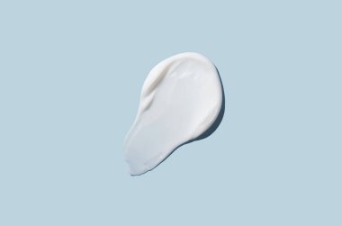 Mavi arka planda kozmetik krem dokusu. Cilt bakımı.