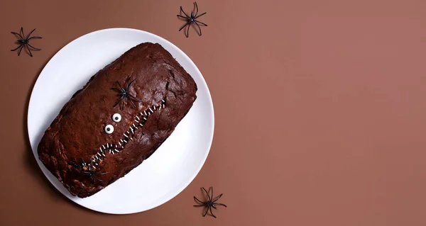 Stock image Halloween food. Scary chocolate cake with eyes and spiders on a light background. Terrible food. Thematic food. Halloween background. Copy space.