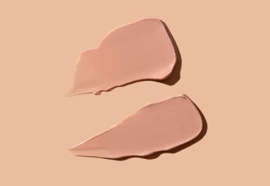 Bej bir arka planda kozmetik krem lekesi. Cilt için ton kremi. Cilt bakımı.