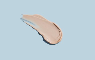 Mavi arka planda kozmetik krem dokusu. Cilt bakımı.