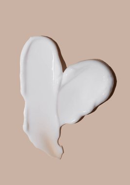 Bej bir arka planda kozmetik krem lekesi. Cilt bakımı.