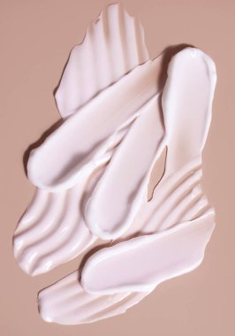 Bej bir arka planda kozmetik krem lekesi. Cilt bakımı.