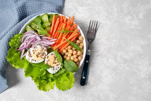 Diet menu. Plate with fresh vegetables, egg and chickpeas on light table. Copy space