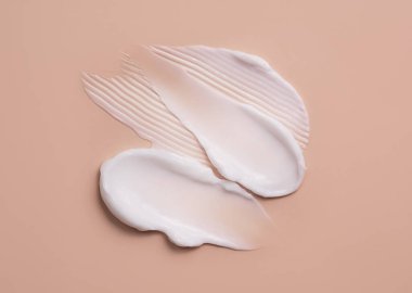 Bej bir arka planda kozmetik krem lekesi. Cilt bakımı.