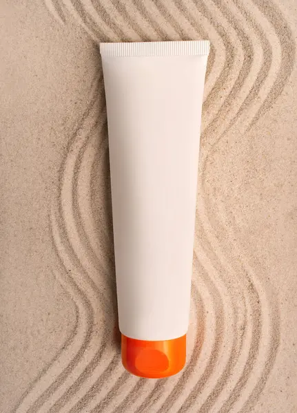 Sunscreen tube mockup. A tube of cream on the sand. SPF cream. The concept of UV protection.