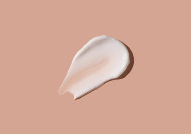 Bej bir arka planda kozmetik krem lekesi. Deriyi nemlendirir..