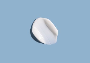 Mavi arka planda kozmetik krem dokusu. Cilt bakımı.