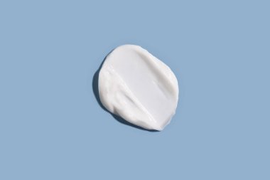 Mavi arka planda kozmetik krem dokusu. Cilt bakımı.