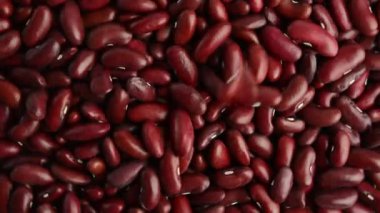 Kırmızı fasulyeler fırıl fırıl dönüyor. Çiğ fasulye. Yukarıdan görüntüle.