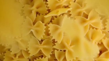 Çiğ farfalle makarna, kıvrılmış ve üzerine serpiştirilmiş. Kelebek ya da fiyonk şeklinde makarna. Yukarıdan görüntüle.