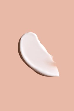 Bej bir arka planda kozmetik krem lekesi. Cilt bakımı.