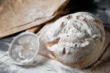 Tahta zemine serpiştirilmiş un serpiştirilmiş taze ekmek.