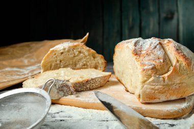 Tahta bir masada dilimlenmiş taze ekmek.