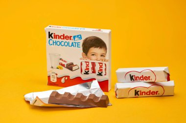 LVIV, UKRAINE - 27 Haziran 2024: Sarı zemin üzerinde Kinder çikolatası ve küçük çikolata paketleri