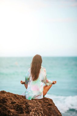 Young woman practicing yoga at seashore. High quality photo