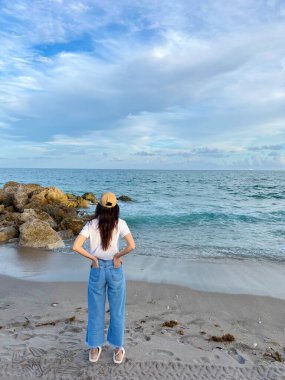 Kumsalda genç ve mutlu bir kadın.