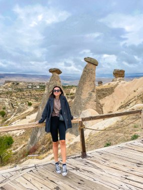 Young happy woman traveler on vacation in Cappadocia. Cave formations. High quality photo