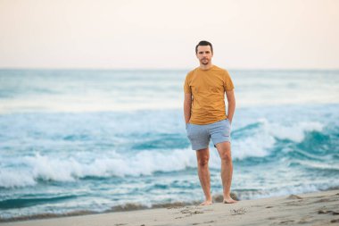 Young man on the beach at sunset