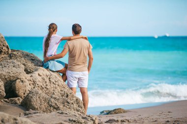 Young father and little daughter on the beach enjoy their time together