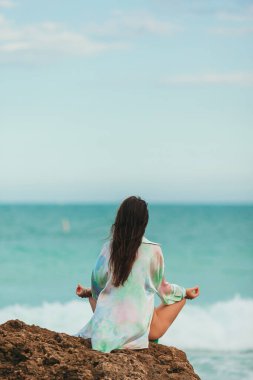 Young woman practicing yoga at seashore. High quality photo