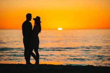 Romantic couple in love on the beach at sunset on romantic honeymoon travel