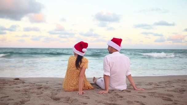 Χριστούγεννα Ευτυχισμένο Ζευγάρι Σάντα Καπέλα Για Διακοπές Στην Παραλία — Αρχείο Βίντεο