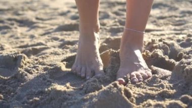 Female legs on the beach closeup.