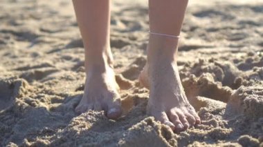 Female legs on the beach closeup.